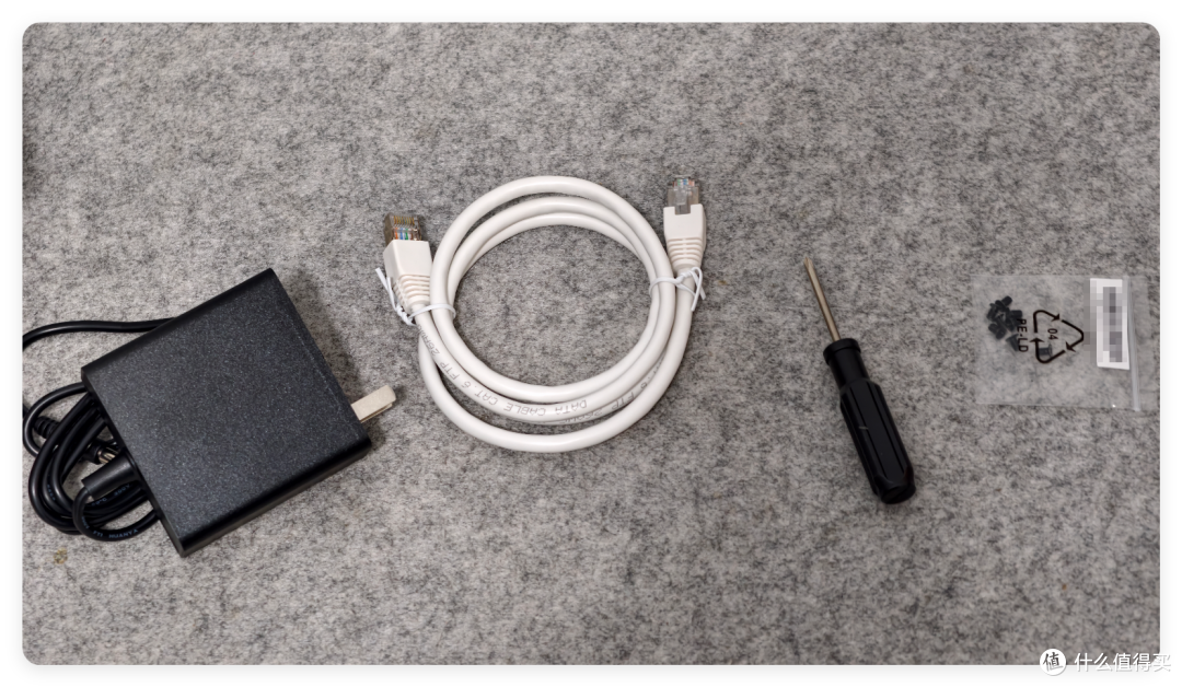 配件包平铺：12V/5A 电源适配器、网线、螺丝刀与硬盘螺丝
