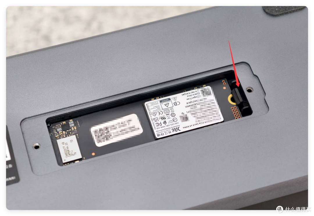 机身底部 M.2 2280 硬盘位：免工具卡扣，已装入 NVMe 固态（红箭头指向卡扣）